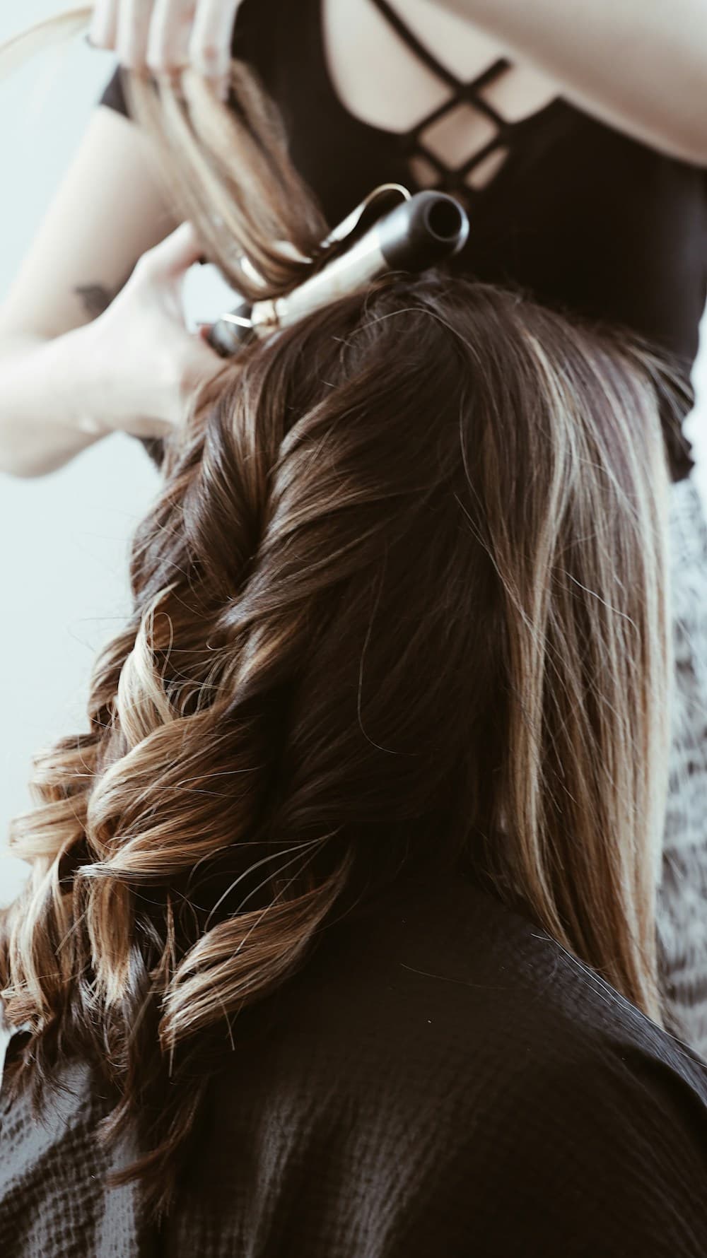 Cabelo castanho com mechas iluminadas e cachos modelados